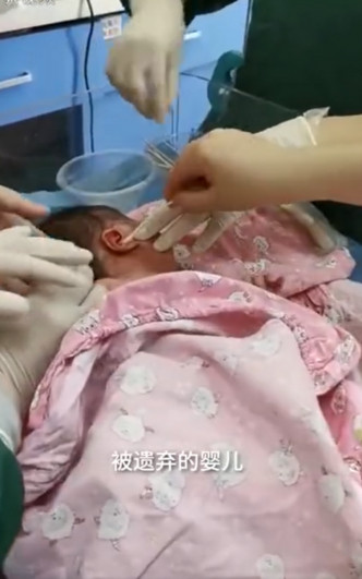 醫護為女嬰清理耳內的蛆蟲。網圖