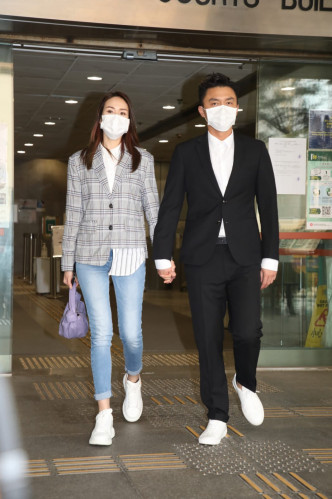 杨明和女友庄思明十指紧扣步出法院，二人停步让传媒拍照。