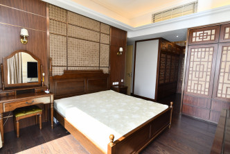 套房寢區大部分都用上深木色布置，兩側掛上壁燈。