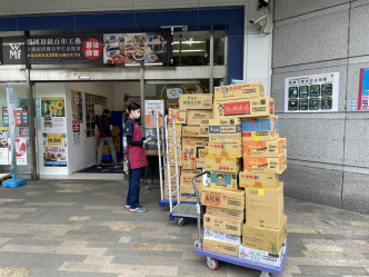 超市人员将一箱箱泡面、零食摆放在超市外备用。网图
