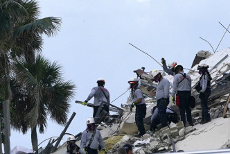 救援人員在瓦礫搜索生還者。AP圖片
