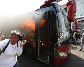 一名女子逃离著火的巴士。AP
