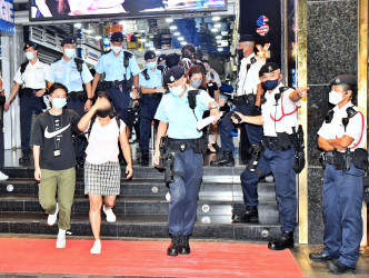 西九龙总区行动部高级警司谭雅静（右）及警司高振邦（右二）带队进行代号「撒哈拉」反罪恶行动。图为其中一名女疑人(左二)被带署。