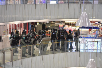 防暴警察驱散商场内的人。
