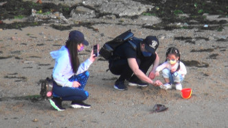 城城于石滩踎低陪大宝捉蟹仔，太太就在旁举机捕捉父女温馨时光。