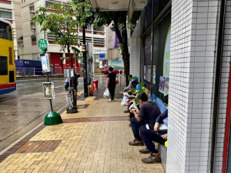 市民坐在馬路旁邊享用午餐。（網上圖片）