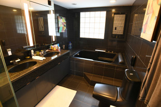 浴室设计沉实奢华，以深啡色砖材铺设。