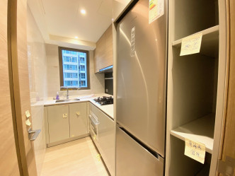 廚房備有多組廚櫃，並設L字形工作枱面。
