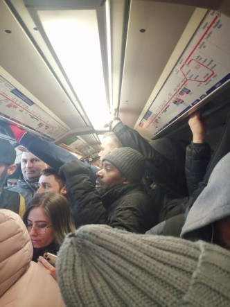 英國地鐵車廂內逼滿乘客，乘客逼迫肩碰肩背貼背。網圖