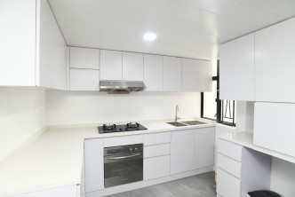 厨房设有多组白色厨柜，收纳空间多。