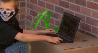 男童在校外借用无线网络。网图