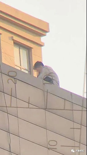 該男子危坐在棟大廈天台，期間撒下多張人民幣鈔票。網圖