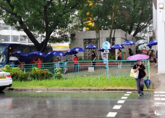 屯门有小学职员排起伞阵，方便乘校巴回校的学生进入校园。屯码牛牛Facebook图片