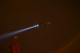 直升机开照明灯协助。