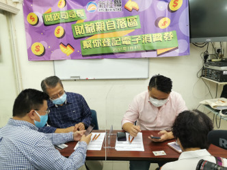 財政司司長陳茂波落區協助市民登記領取電子消費券。