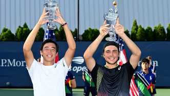 两位青少年球手高举奖杯 。 美国网球公开赛官方图片