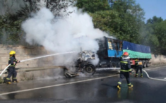 消防员往车头喷水，防止油箱爆炸。网图