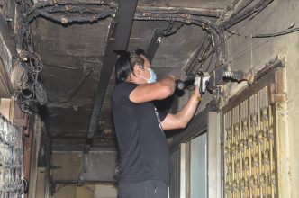 由於電線被燒毀，住客自行找來電器技工搶修。林思明攝