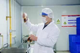 王少波正在随机检查兔头塑封是否合格。网上图片