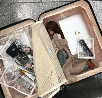 有网民将智能公仔放入行李箱内，和「她」一起去旅行。