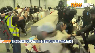 妇人曾上前阻拦警员被推开。NOW新闻截图