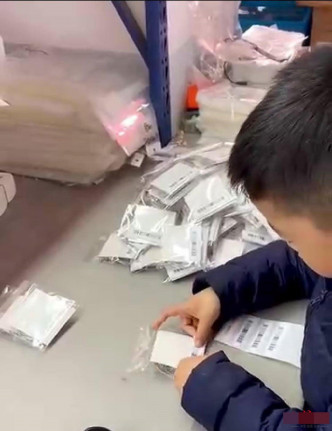 男童透过为包装袋贴标签赚钱。网图