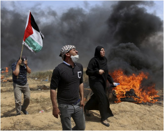 示威者揮舞巴勒斯坦旗幟和焚燒舊車胎。 AP