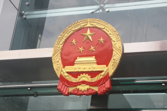 中联办职员深夜拆下被示威者弄污的国徽，换上新的。