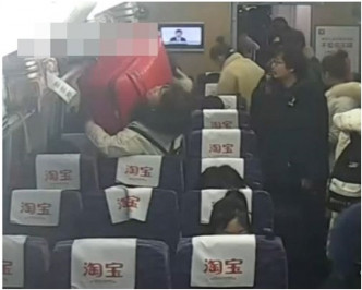 行李往架上放但甩手下墮砸晕行李架下的女乘客。