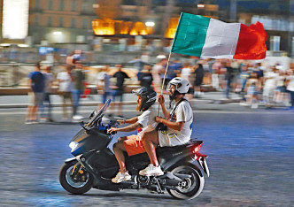 有球迷高举意大利国旗游街。