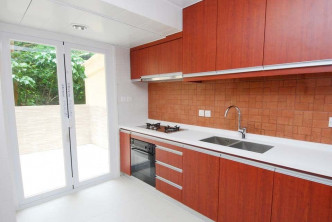 廚房以啡紅色為主調，配有多組廚櫃。