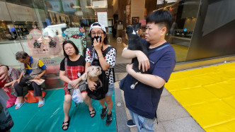 岑小姐（中）与家人抱著两头爱犬逃生。