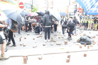 示威者投擲磚頭雜物出路面。