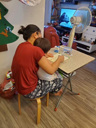 網民兒子坐在外傭大腿上學寫字。網民龍家輝圖片