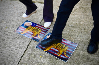 有人將印有美國總統拜登頭像的紙張放在地上狂踩。