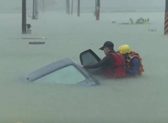 台湾嘉义县今日传出有车辆因水淹被困，消防员游泳进行救援。网图