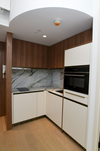 開放式廚房設曲尺工作枱及多組櫥櫃。（18樓A室交樓標準示位）