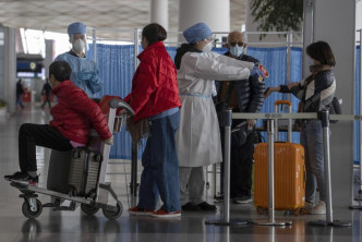 北京機場人員為抵京人士檢測體溫。AP