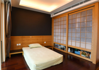 房間以日式為主調，一側貯物櫃以淺木及和紙裝飾。