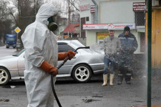 工人忙于在街上进行消毒。AP