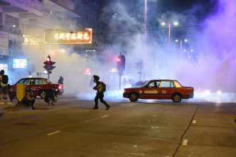 警方发射催泪弹时，现场仍有不少汽车在路中心。