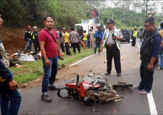 一辆旅游车今天在印尼爪哇岛一处斜坡路段，撞上一辆电单车后翻滚。网上图片