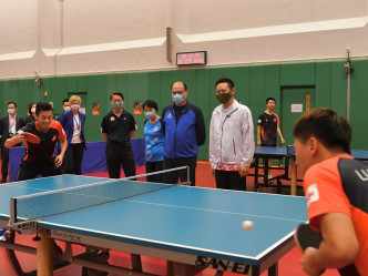 徐英偉（右二）和林大輝（右三）觀看乒乓球運動員黃鎮廷（前排左一）與隊友練習的情況。