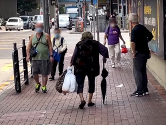 老妇外出时带同垃圾到街外丢弃。影片截图
