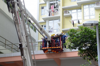 消防員架起雲梯救出墮樓男子。歐陽偉光攝