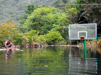 篮球场被淹得只剩下半节篮球架。（中新网）