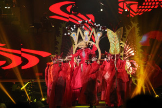 著住紅衫、戴著金色面具的Karen，坐在由舞蹈員抬著的花轎出場。