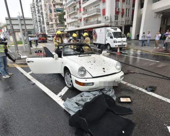 跑車停在路中，消防員將火救熄。楊偉亨攝