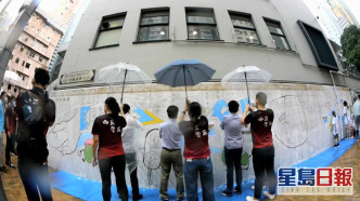壁畫塗色活動進行期間一度下雨，一批西區警務人員貼心地為參與者打傘，並讓參與的小孩穿上雨衣。