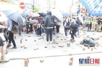 示威者掘起砖头投掷到马路。